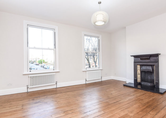 Large Room With Fireplace And Radiators